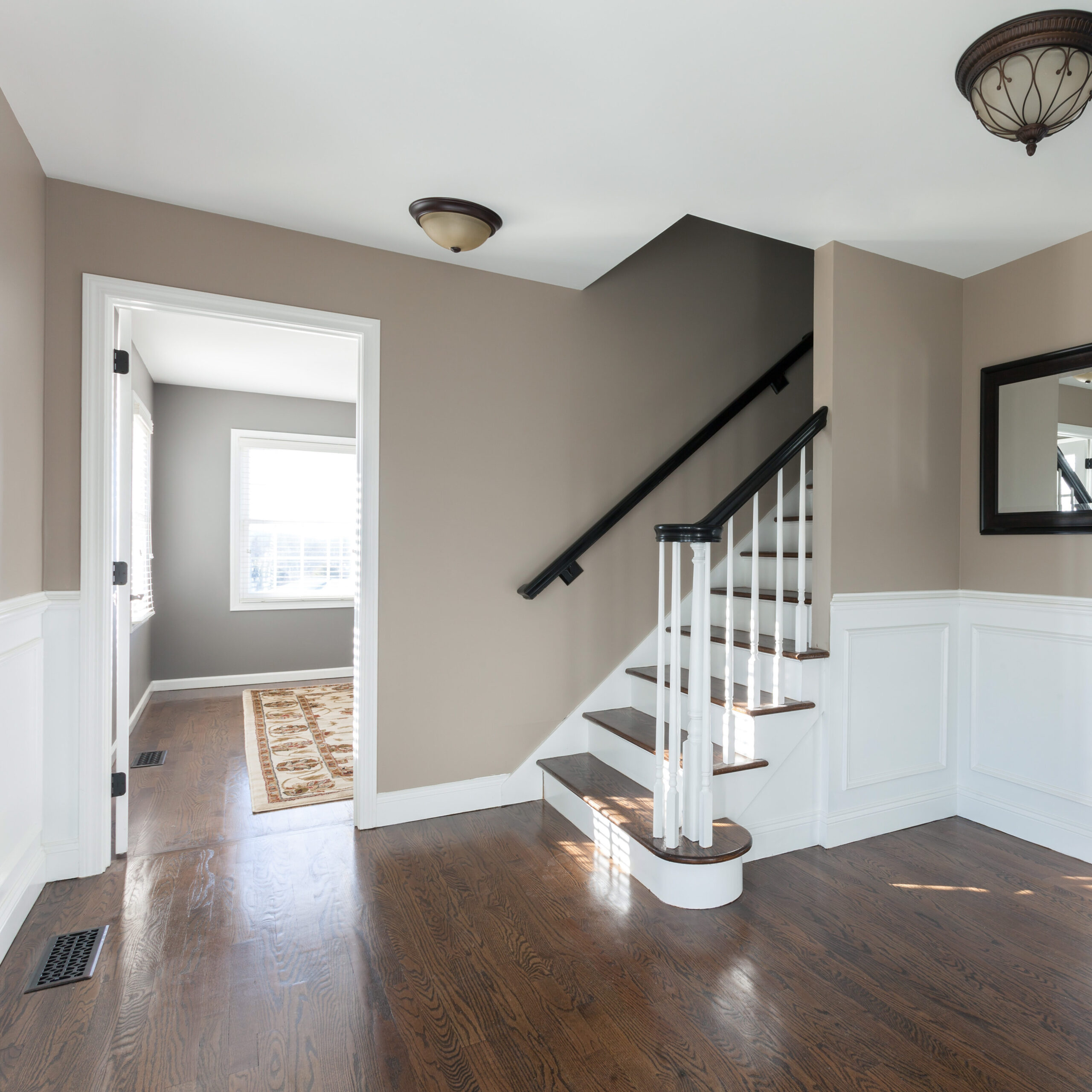New house entryway interior room with wood floors and staircase.